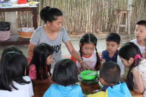 Photo: Our staff Jiew and a child holding a strainer to wash tapioca pearls